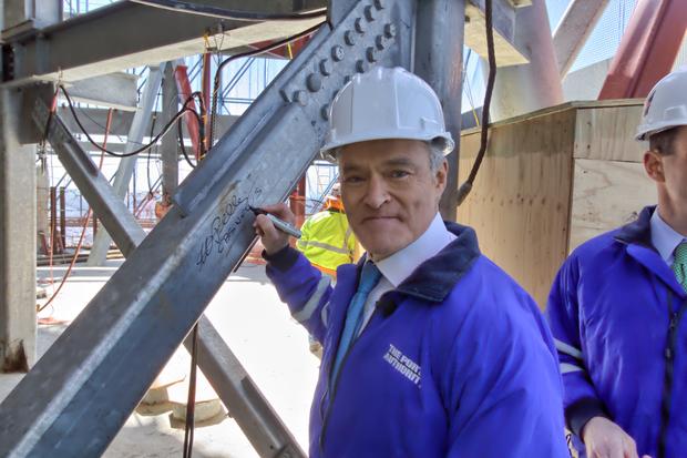 Scott Pelley signs a steel beam on the roof of One World Trade Center. 