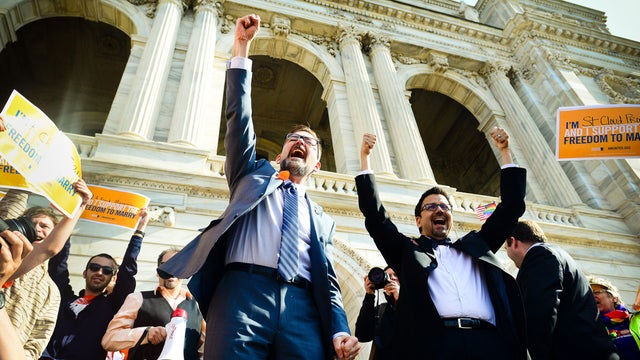 Sen. Scott Dibble, DFL-Minneapolis, left, sponsor of the gay marriage bill in the Minnesota Senate, and his partner Richard Leyva greet a large, joyous crowd as the arrive at the Minnesota State Capitol in St. Paul, Minn. on Monday, May 13, 2013. 