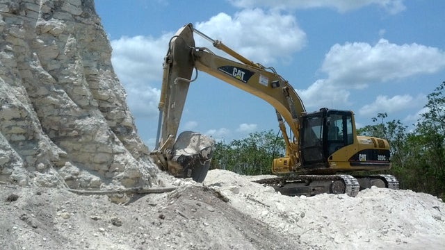 In this image released by Jaime Awe, head of the Belize Institute of Archaeology on Monday May 13, 2013, a backhoe claws away at the sloping sides of the Nohmul complex, one of Belize's largest Mayan pyramids on May 10, 2013 in northern Belize. 