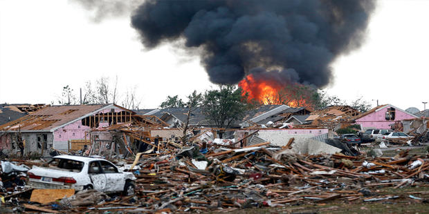 A fire burns in the Tower Plaza Addition in Moore, Okla., following a tornado Monday, May 20, 2013. A tornado as much as a mile (1.6 kilometers) wide with winds up to 200 mph (320 kph) roared through the Oklahoma City suburbs Monday, flattening entire nei 