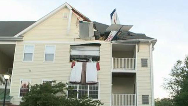 Tail of small plane can be seen sticking out of apartment after, authorities say, it ran out of fuel and crashed into building in Herndon, Va. on May 31, 2013. At least 2 people suffered minor injuries. 