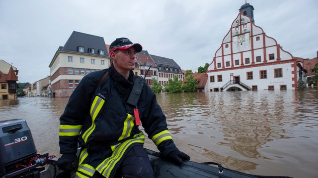 A firefighter floats through flooded city of Gamma, Germany 