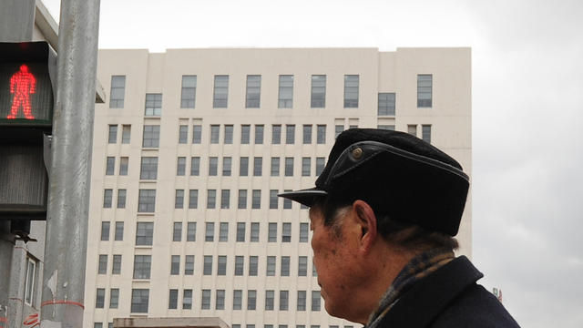 A man walks past a 12-storey building alleged in a report on February 19, 2013, by the Internet security firm Mandiant, to be home of a Chinese military-led hacking group, in Shanghai 