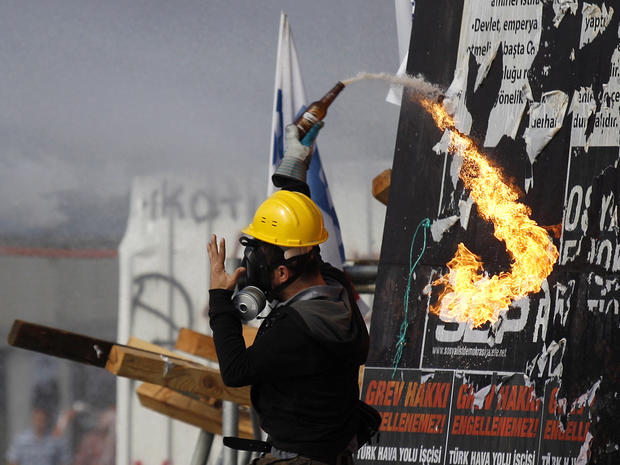 A protester throws a molotov cocktail at riot police during clashes in Taksim Square 
