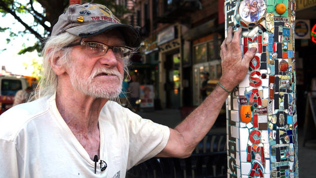 Jim Power stands next to one of his lamppost mosaics on St. Mark's Place in the East Village. 
