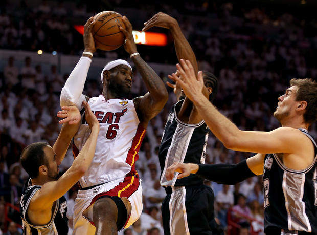 LeBron James of the Miami Heat looks to pass against Manu Ginobili  and Kawhi Leonard of the San Antonio Spurs in the second quarter during Game 7 of the 2013 NBA Finals at AmericanAirlines Arena on June 20, 2013 in Miami, Florida.  
