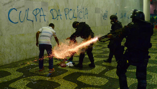 Anti riot police officers fire tear gaz in a corridor after clashes erupted during a protest against corruption and price hikes, on June 20, 2013, in Rio de Janeiro. Brazilians took to the streets again Thursday in several cities on a new day of mass nationwide protests, demanding better public services and bemoaning massive spending to stage the World Cup. 