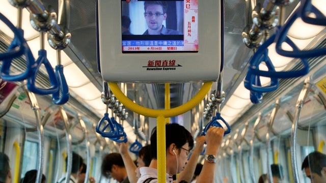 A TV screen shows news about Edward Snowden, a former CIA employee who leaked top-secret documents about sweeping U.S. surveillance programs, in the underground train in Hong Kong June 16, 2013. 