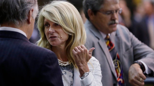 Sen. Wendy Davis, D-Fort Worth, talks with Sen. Kirk Watson, D-Austin, left, after she was called for what was called third and final violation of rules to end her filibuster 