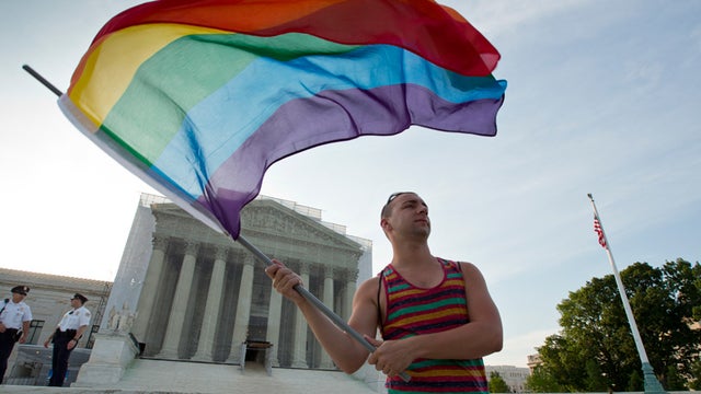 Gay rights advocate Vin Testa waves a rainbow flag in front of the Supreme Court at sun up in Washington, Wednesday, June 26, 2013. Justices are expected to hand down major rulings on two gay marriage cases that could impact same-sex couples across the co 