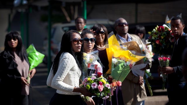 Mandela relatives carry flowers into the Pretoria hospital where he is being treated 