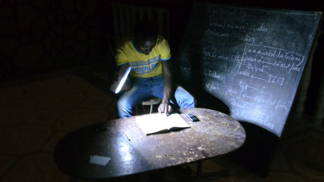 A student does his homework on June 18, 2013, with a flashlight in Niamey, the capital of Niger, during an electrical blackout.  