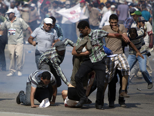 Supporters of ousted Egyptian president Mohammed Morsi rush to help a wounded man after clashes erupted outside the Cairo headquarters of the Republican Guard 