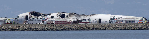 The wreckage of Asiana Flight 214 sits where the plane crashed at San Francisco International Airport in San Francisco, Saturday, July 6, 2013.  
