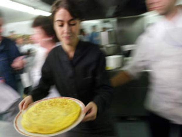 A waitress carries an omelette to be jud 