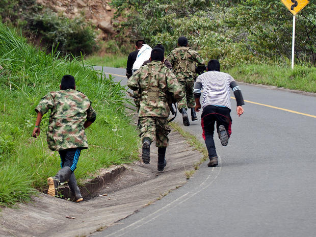 Revolutionary Armed Forces of Colombia (FARC) guerrillas run as the police nears, in the rural area of Caloto, department of Cauca, Colombia, on June 4, 2013, after putting mines along the road between Caloto and Toribio. 