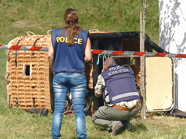 Swiss police examine the basket of a hot air balloon which crashed in the town of Montbovon 