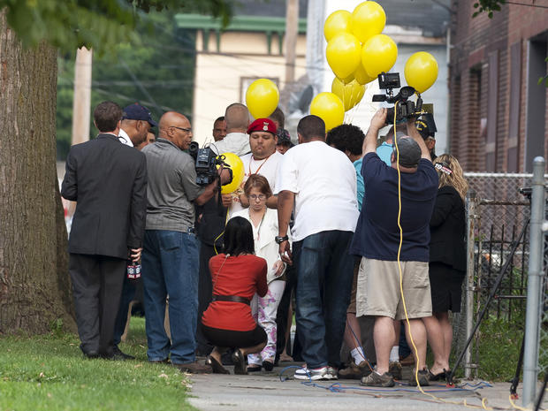 Michelle Knight, center, talks with reporters Aug. 7, 2013, outside the home of Ariel Castro in Cleveland. 