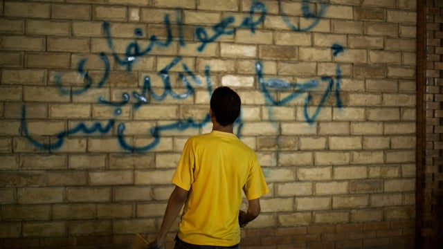  supporter of ousted Egyptian President Mohammed Morsi paints graffiti on the wall of a Coptic Church in Assiut, Upper Egypt. 