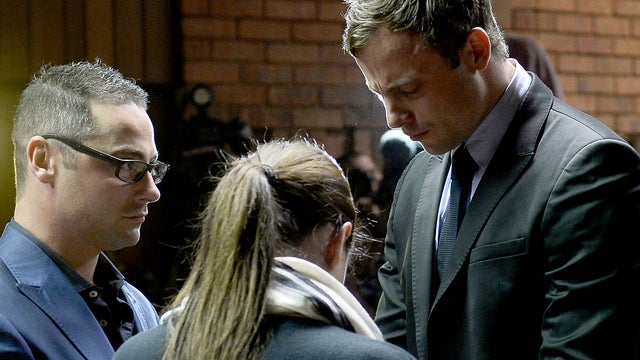 South African Olympic sprinter Oscar Pistorius, right, prays with his sister Aimee and his brother Carl in a Pretoria court 