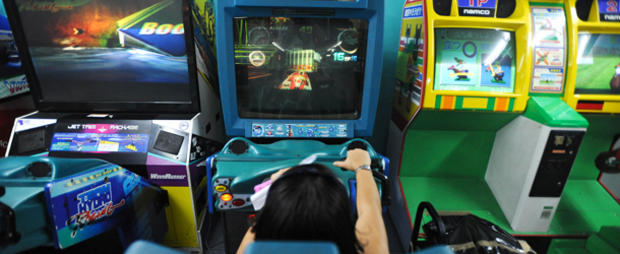 A person plays a racing game at an arcad 
