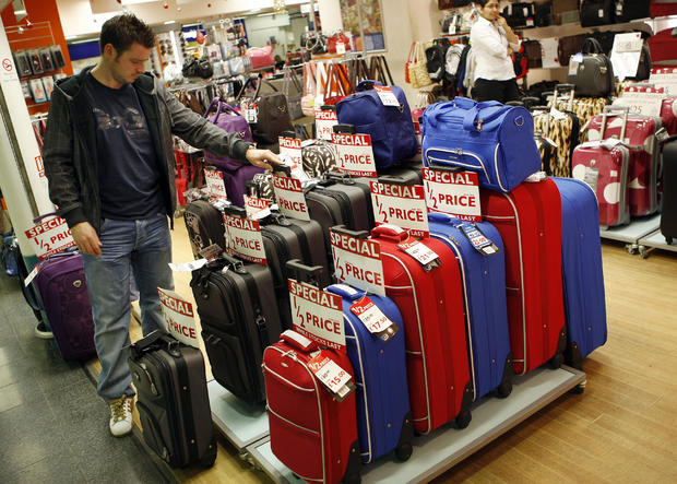 A man browses the suitcases which are on 