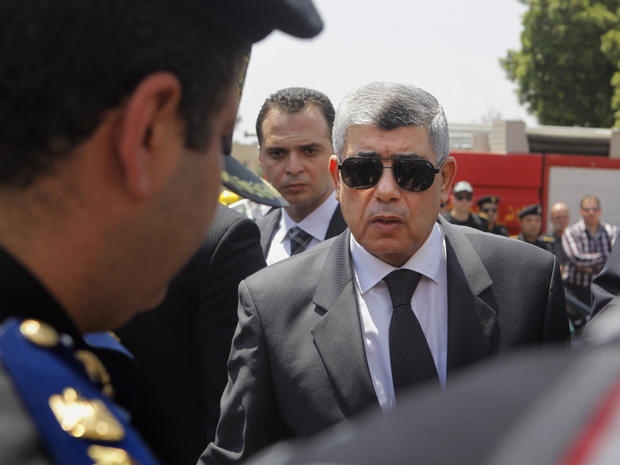 Egyptian Interior Minister Mohammed Ibrahim, right, gives his condolences to a policeman during a military funeral in Cairo, Egypt. Aug. 15, 2013. 