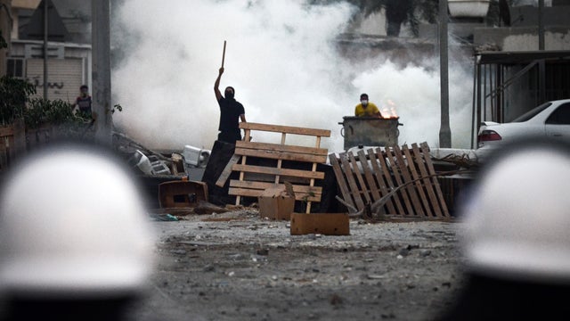 A Bahraini protester stands behind a makeshift barricade during anti-regime demonstration in North Sehla, west of Manama. 