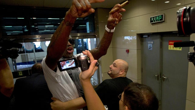 Retired NBA star Dennis Rodman, center, gestures as he reacts to a question about American citizen Kenneth Bae who remains imprisoned in North Korea, at the Beijing capital airport in Beijing, China, Saturday, Sept. 7, 2013. 