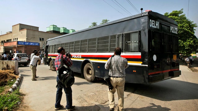 Photographers gather by a van carrying four men accused in the fatal gang rape of a young woman on a moving New Delhi bus 