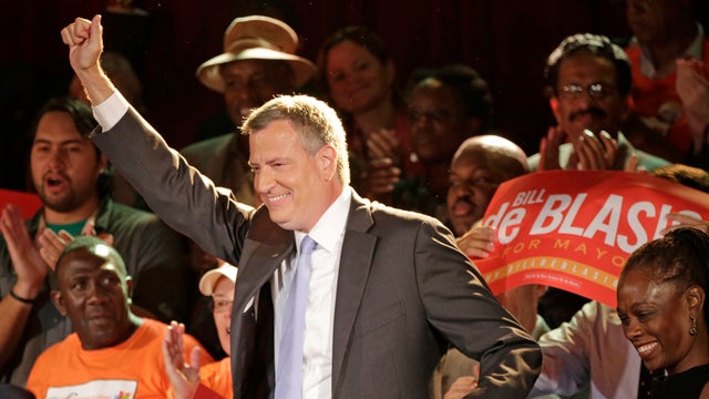 New York City Democratic Mayoral hopeful Bill De Blasio raises his arms as he arrives with his wife, Chirlane, right, on stage to speak to supporters at his election headquarters after polls closed in the city's primary election Wednesday, Sept. 11, 2013. 