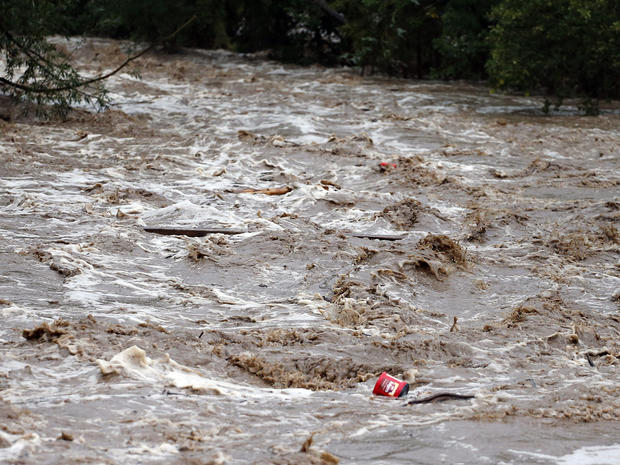 Debris floats down the overflowing St. Vrain River following overnight flash flooding, one mile east of Lyons, Colo., Thursday, Sept 12, 2013. Flash flooding in Colorado has left widespread high waters that are keeping search and rescue teams from reachin 