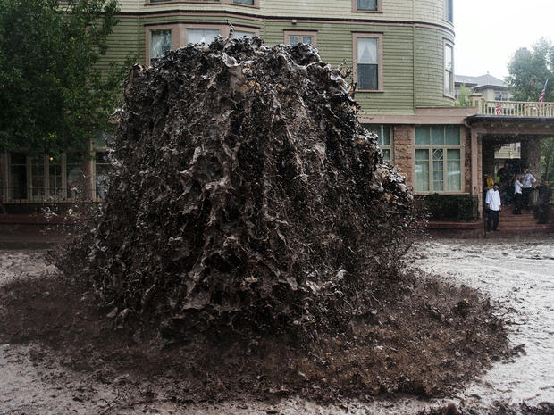 Flood water shoots out of a sewer next to the Cliff House in Manitou Springs, Colo., Sept. 12, 2013. 