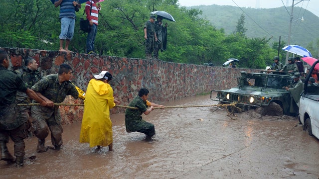 Army soldiers work to try to get their vehicle out of a flooded portion of a road caused by Tropical Storm Manuel in the city of Chilpancingo, Mexico, Sunday Sept. 15, 2013. In the southern Pacific Coast state of Guerrero, rains unleashed by Manuel result 