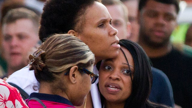 Family and friends wait to greet staff of the Naval Sea Systems Command headquarters as they are bused from the Washington Navy Yard to Nationals Park in Washington Sept. 16, 2013. 