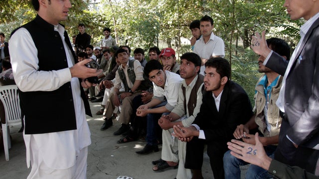 Afghan men wait to register at a voter registration center in Kabul 