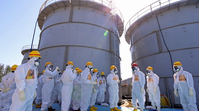 Japanese Prime Minister Shinzo Abe, third right, wearing a red helmet 