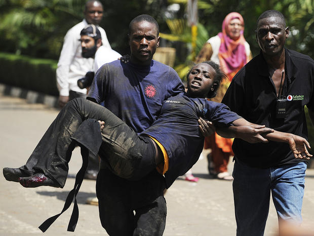 A Kenyan woman is helped to safety after masked gunmen stormed an upmarket mall and sprayed gunfire on shoppers and staff Sept. 21, 2013, in Nairobi, Kenya. 