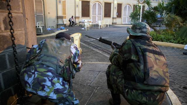 Kenya security personnel take cover outside the Westgate Mall  