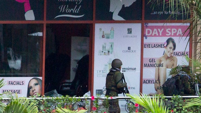 Kenyan soldier prepares to enter Westgate Mall following bout of heavy gunfire just after dawn, in Nairobi, Kenya Sept. 24, 2013 