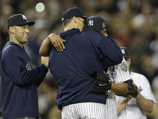 New York Yankees shortstop Derek Jeter, left, watches as starting pitcher Andy Pettitte, center, embraces a sobbing Mariano Rivera on the mound in the ninth inning of Rivera's final appearance in a game at Yankee Stadium, against the Tampa Bay Rays on Sept. 26, 2013. The Rays won, 4-0. 