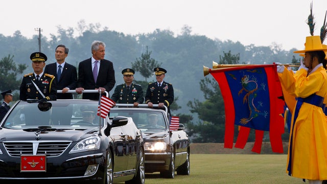 South Korean Defense Minister Kim Kwan-jin, second from left, rides in convertible with U.S. Secretary of Defense Chuck Hagel, center, followed by Gen. Jung Seung-jo, back left, chairman of South Korea's Joint Chiefs of Staff, and Gen. Martin Dempsey, cha 