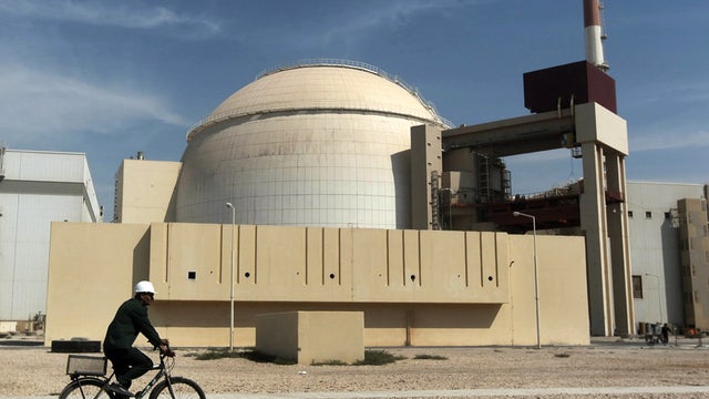 A worker rides a bicycle in front of the reactor building of the Bushehr nuclear power plant just outside the southern city of Bushehr, Iran, Oct. 26, 2010. 