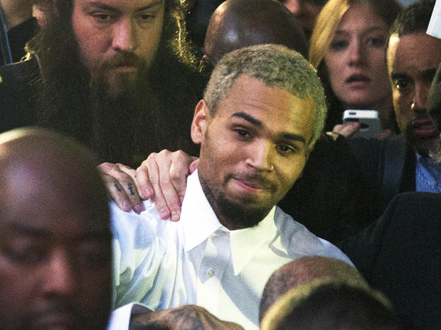 Singer Chris Brown, center, departs the H. Carl Moultriel courthouse Monday, Oct. 28, 2013, in Washington. 