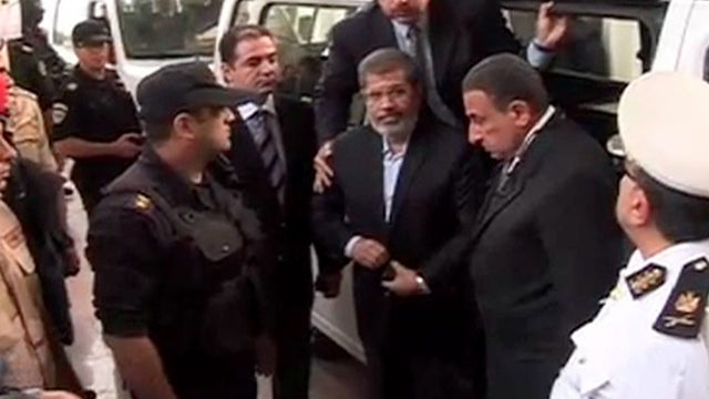 Ousted President Mohammed Morsi,center, arrives for a trial hearing in Cairo, Egypt 