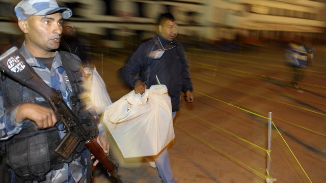 A Nepalese election worker carries ballot boxes to an office of the electoral commission 