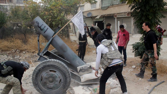 Opposition fighters from the Thu Al-Nurein brigade prepare to fire a homemade cannon in Syria's northern city of Aleppo during clashes with government forces 