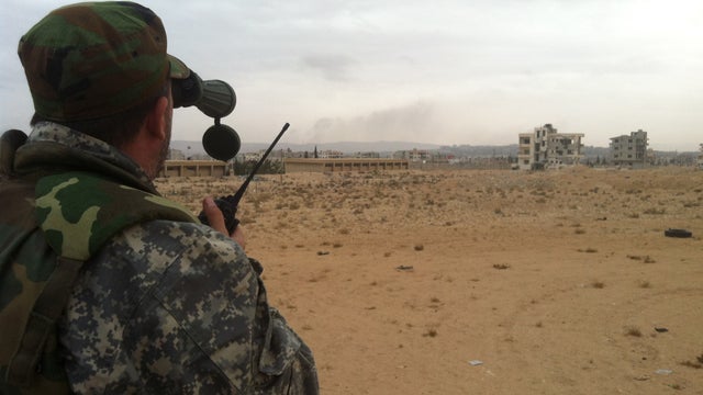 A pro-regime soldier observes rebel fighters' positions through binoculars, Dec. 3, 2013, near Nabek 