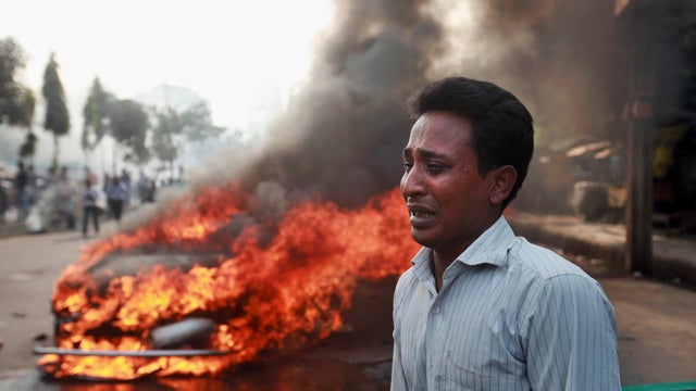 A Bangladeshi man cries after his vehicle was set on fire by Islamist party Jamaat-e-Islami activists following the execution of their party leader Abdul Quader Mollah. 