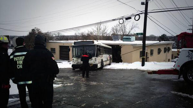 A NJ TRANSIT bus is towed out after it crashed into a building in Paterson, NJ  